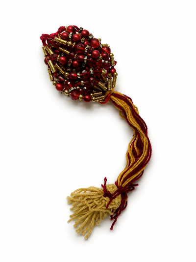 A decorative beaded ornament with a cluster of red and gold beads 