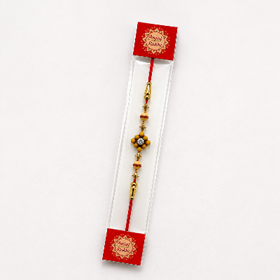 A traditional Indian Rakhi beaded wristlet on a red cord.