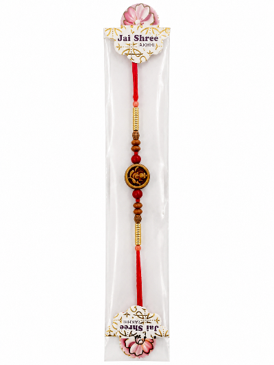 A packaged Jai Shree Lakshmi Rakhi featuring red cord