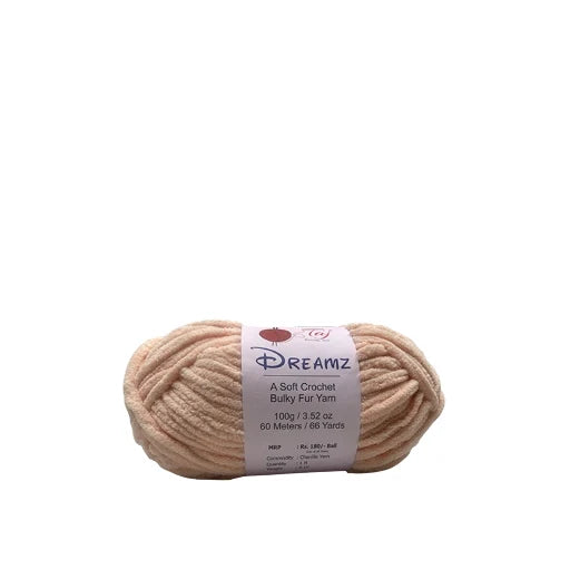 A skein of Dreamz A Soft Crochet Bulky Fur Yarn in a light beige color, with a white paper label 