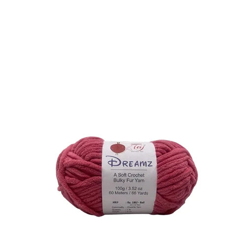 A skein of Dreamz A Soft Crochet Bulky Fur Yarn in a dusty rose pink color, with its white paper label