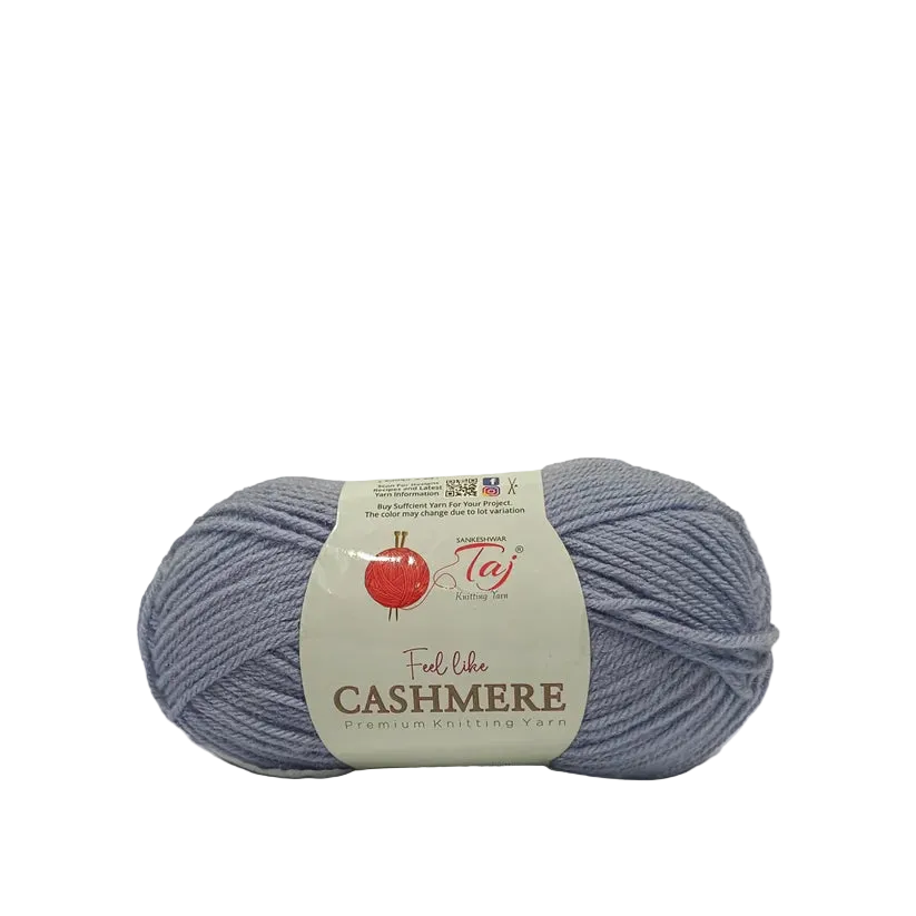 A skein of light periwinkle blue yarn with a cream-colored paper label that reads 'Feel the CASHMERE premium knitting yarn'