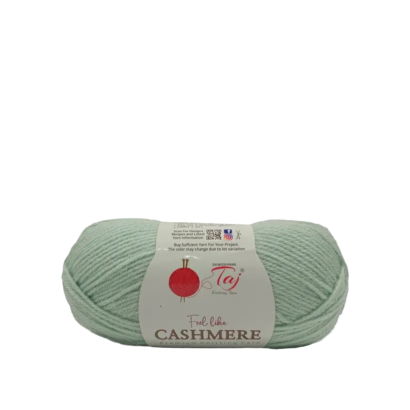 A single skein of pale mint green yarn with a white paper label that reads 'Feel like CASHMERE'
