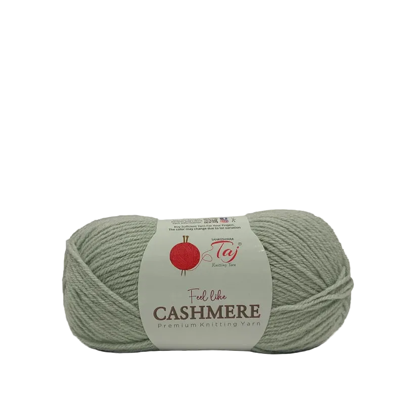 A single skein of Taj Feel Like Cashmere premium knitting yarn in a muted sage green color