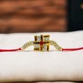 A gold-plated Hindu Rakhi bracelet with a central swastika symbol