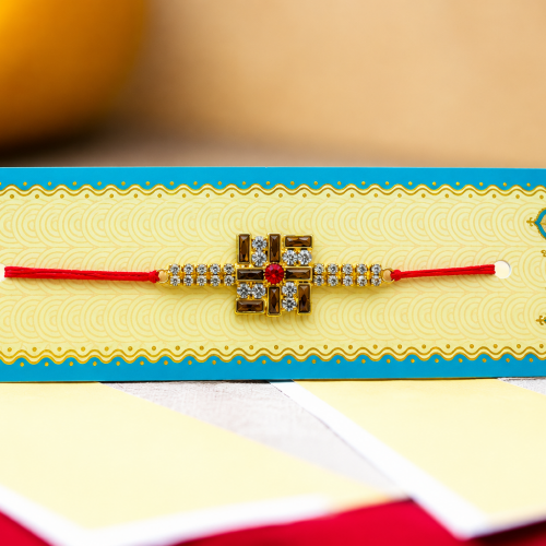 A traditional Indian Rakhi bracelet with a gold-plated cross design,
