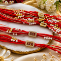 Three red braided Rakhi-style wristlets with gold-tone and white pearl 