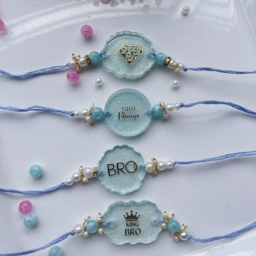 Four light blue beaded baby shower rahuri (luck) bracelets arranged on a