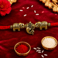 A brass Rakhi bracelet with elephant motifs and a central Ganesha charm
