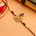 A gold-plated Hindu Rakhi featuring a circular emblem with clear rhinestones, 