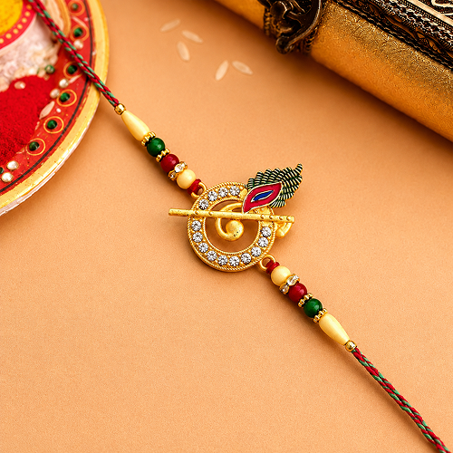 A gold-plated Hindu Rakhi featuring a circular emblem with clear rhinestones, 
