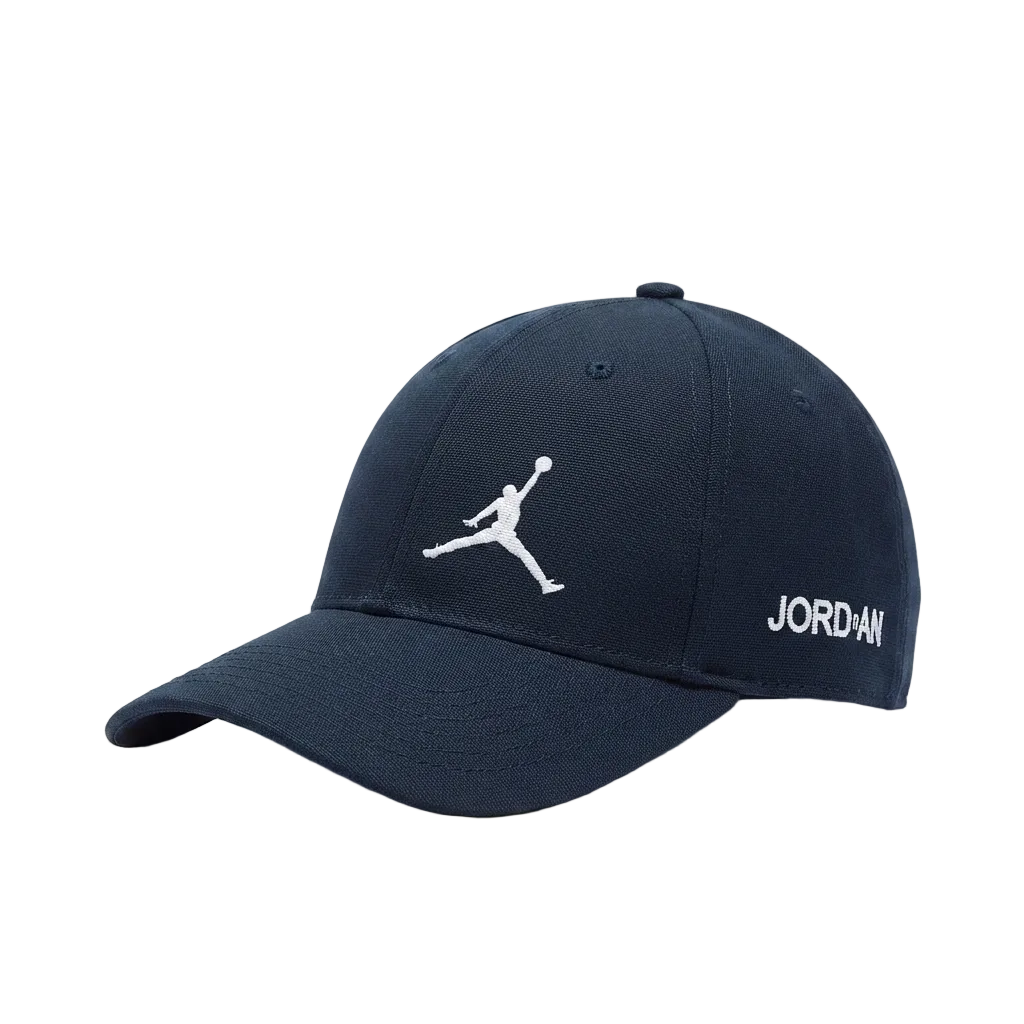 A navy blue baseball cap featuring a white embroidered Jumpman logo on the front and 'JORDAN' text on the side, set against a plain light gray background.