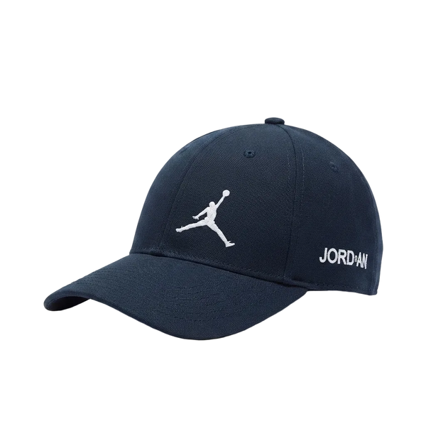 A navy blue baseball cap featuring a white embroidered Jumpman logo on the front and 'JORDAN' text on the side, set against a plain light gray background.