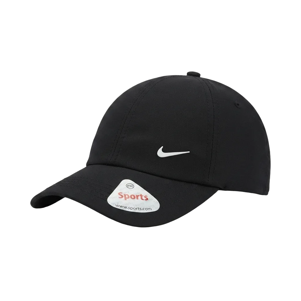 A black Nike baseball cap with a white embroidered Swoosh logo on the front and a white sticker on the brim, photographed on a clean white background.