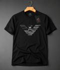 A black short-sleeve crewneck t-shirt by Armani Exchange, featuring a large distressed gray eagle logo on the front