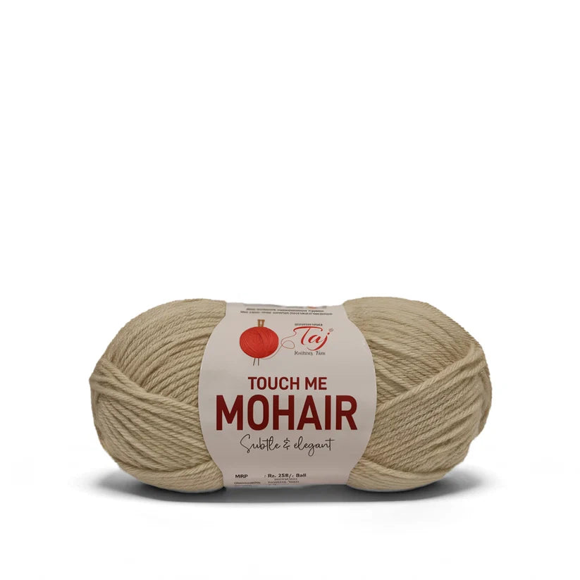 A skein of beige mohair yarn with a white paper label that reads 'TOUCH ME MOHAIR'