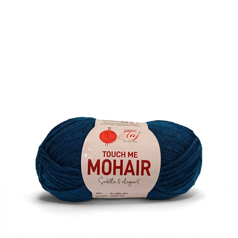 A skein of dark teal blue mohair yarn with a white paper label that reads 'TOUCH ME MOHAIR' 