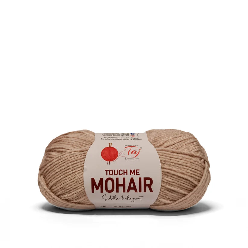 A skein of Taj Touch Me Mohair yarn in a soft beige color, featuring a white paper label