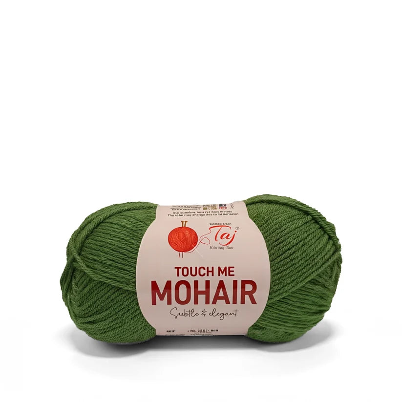 A skein of green mohair yarn with a cream-colored paper label that reads 'TOUCH ME MOHAIR'