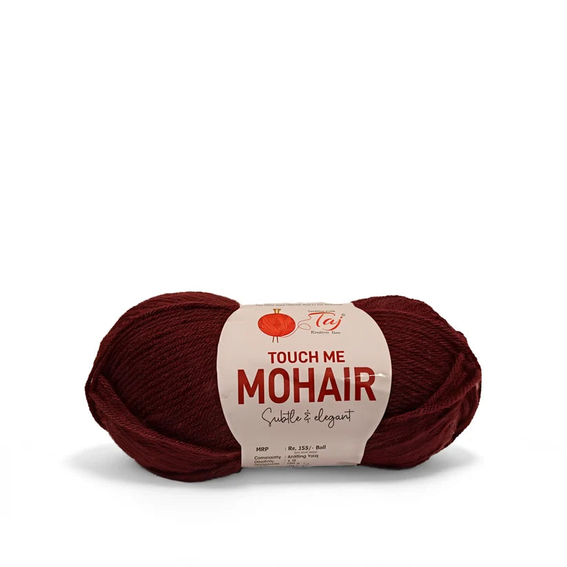 A skein of Touch Me Mohair yarn in a deep burgundy red color, featuring a cream-colored paper label 