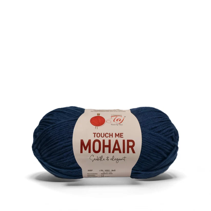 A ball of dark navy blue mohair yarn with a cream paper label that reads 'TOUCH ME MOHAIR'